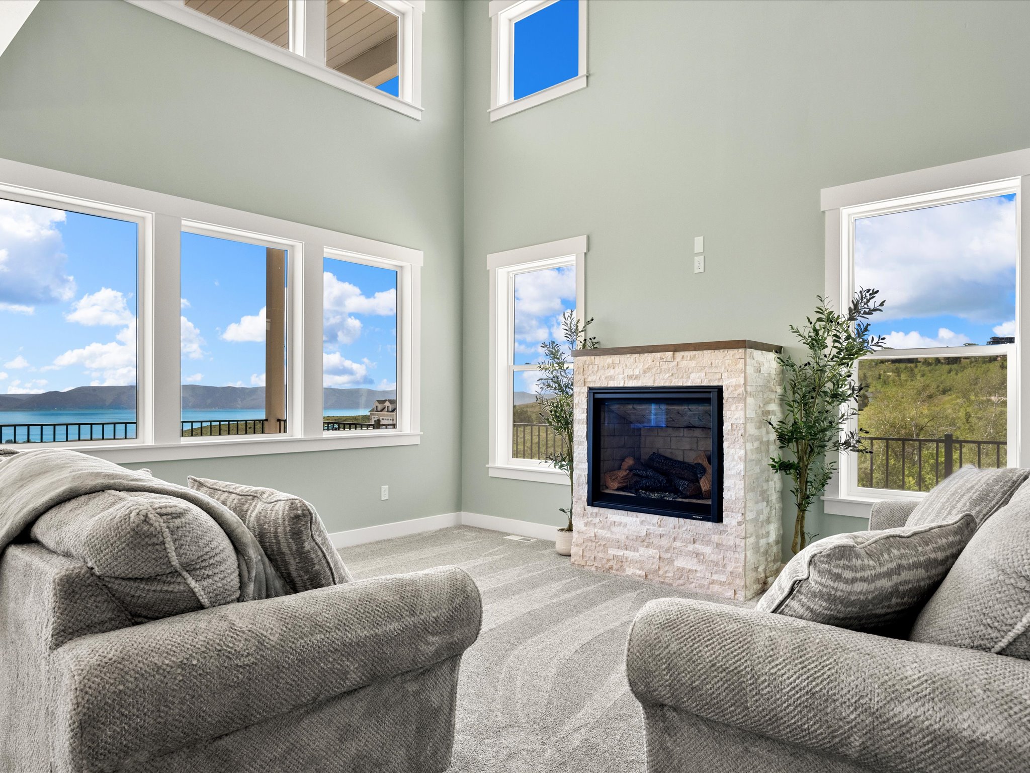 Two-story living area with a stone-clad fireplace and wood mantel