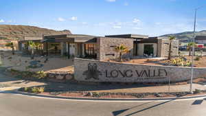 Community / neighborhood sign with a mountain view and a patio