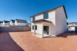 Back of property featuring a fenced backyard, a patio, stucco siding, and a residential view