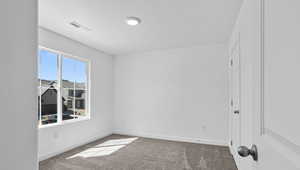 Carpeted spare room with baseboards and a textured ceiling