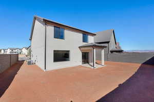 Rear view of house featuring a fenced backyard, a patio area, and stucco siding