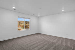 Unfurnished room featuring dark carpet, recessed lighting, and a mountain view