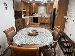 Kitchen featuring dark wood-type flooring, a textured wall, light countertops, freestanding refrigerator, and electric stove