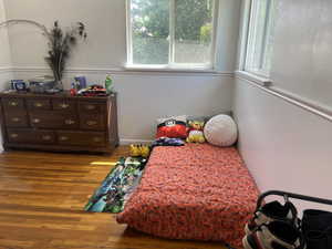 Bedroom with wood finished floors and baseboards