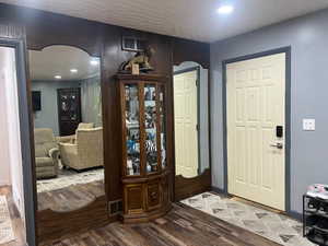 Entrance foyer with arched walkways, dark wood-type flooring, and recessed lighting