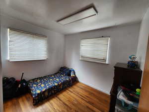 Bedroom featuring wood-type flooring and baseboards