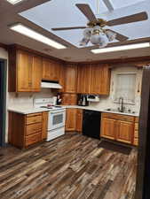 Kitchen featuring wood finish cabinets, a textured ceiling, electric range, light countertops, and a ceiling fan