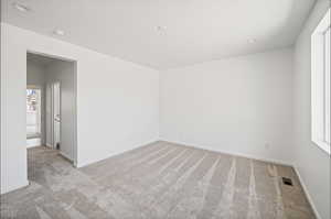 Unfurnished room with light colored carpet and recessed lighting