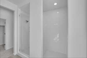 Full bath with a shower stall, recessed lighting, and a walk in closet