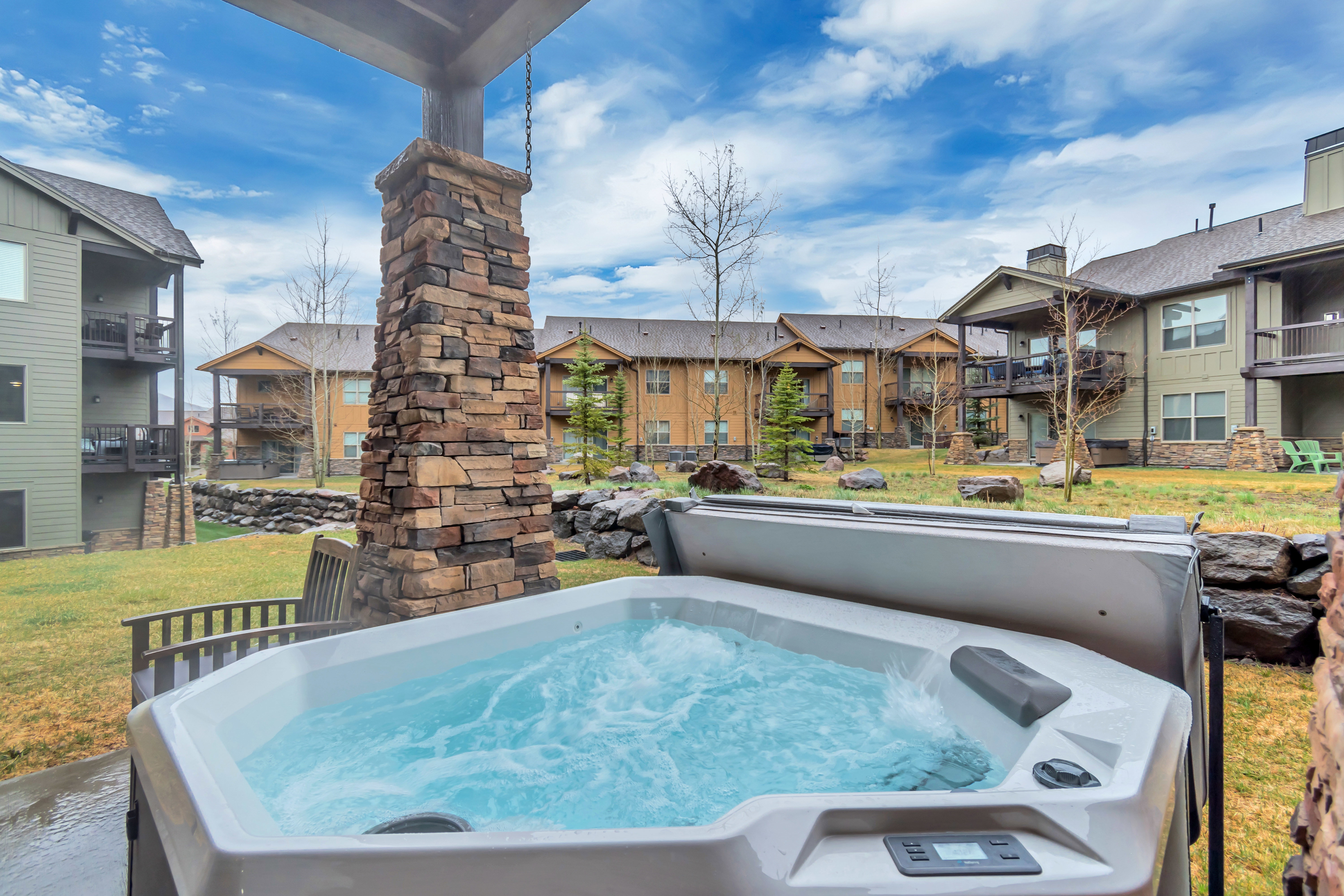 View of pool with a hot tub, a lawn, a residential view, and patio surround