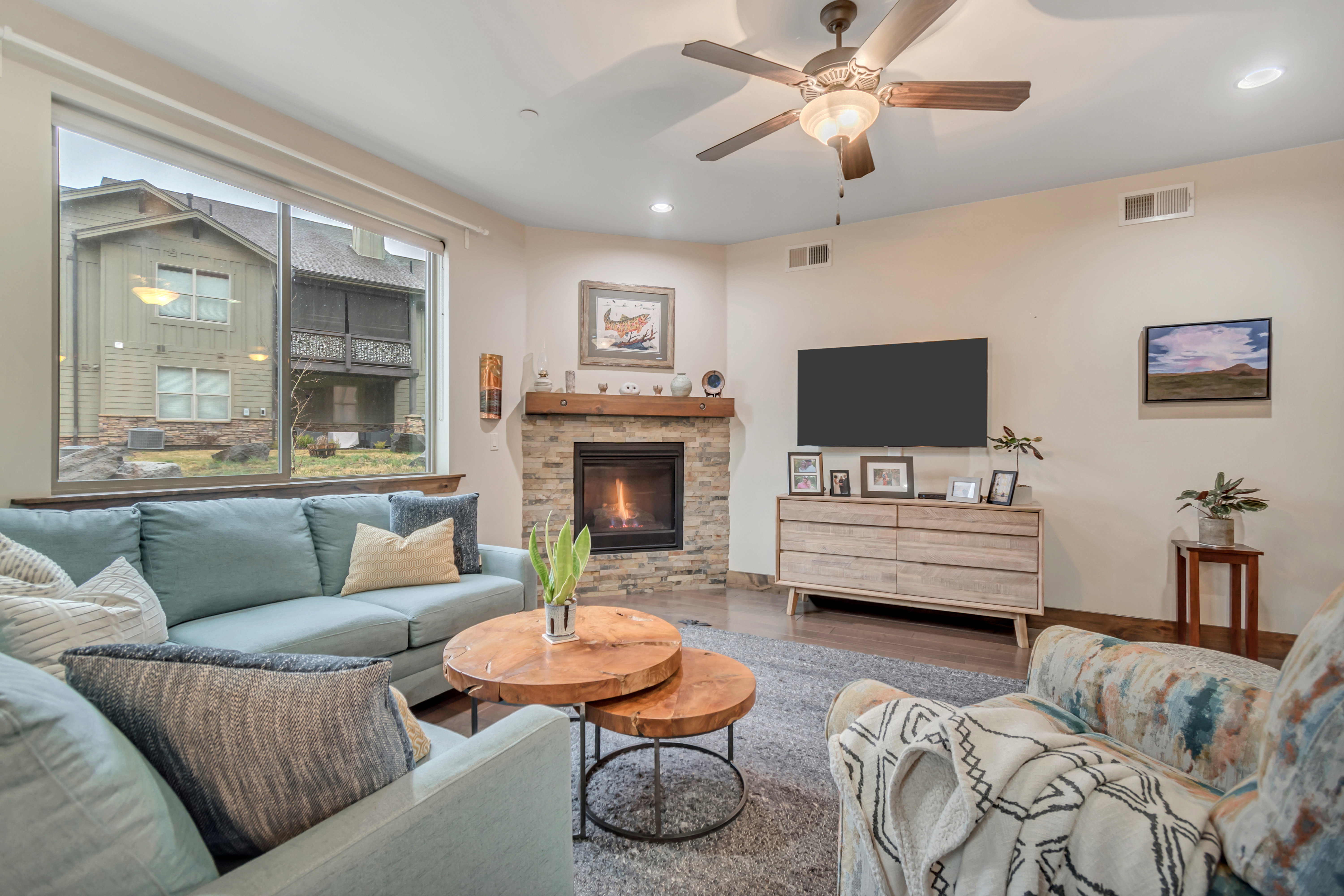 Living area featuring a ceiling fan, wood finished floors, a fireplace, and recessed lighting