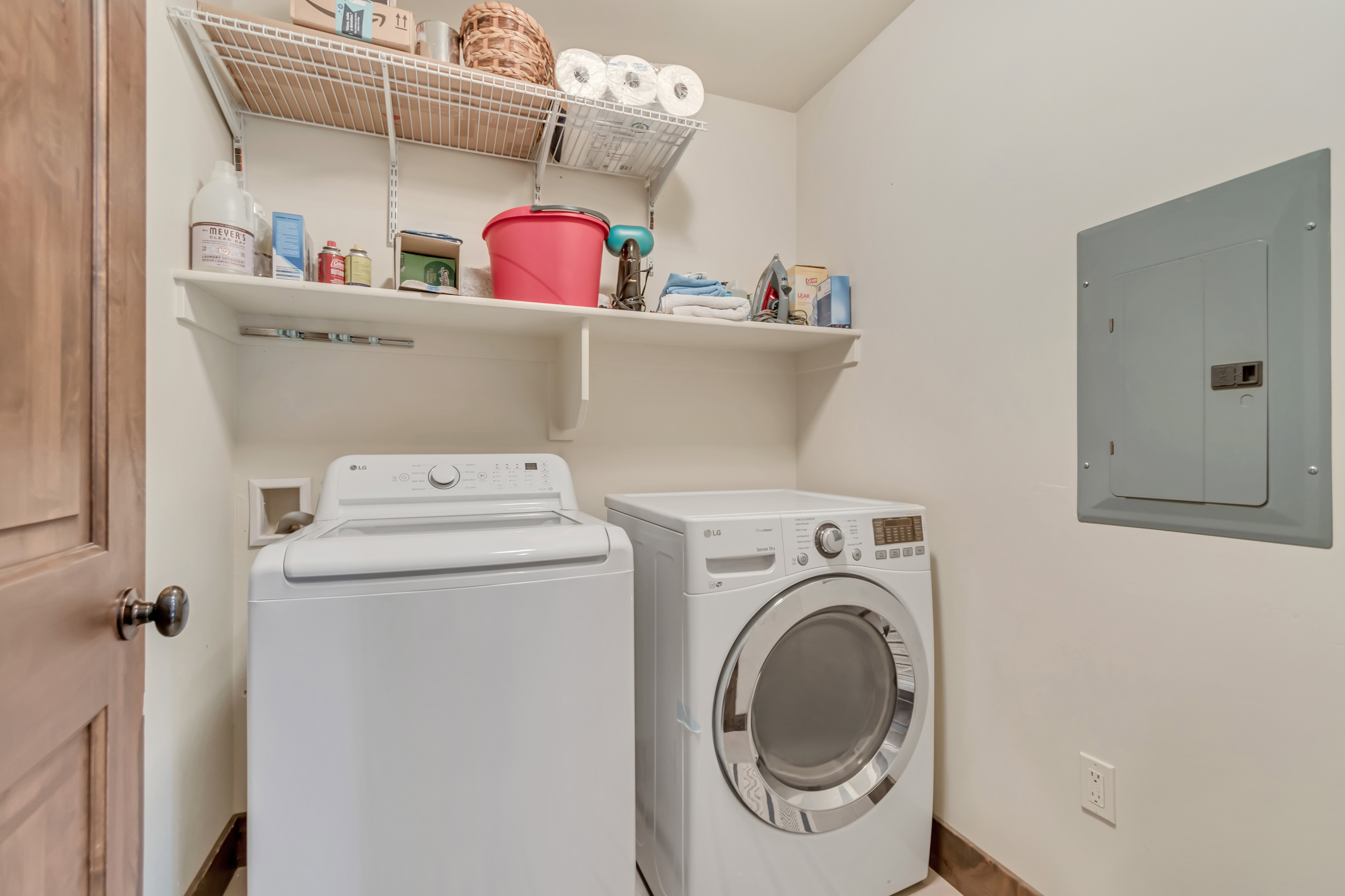 Laundry area featuring electric panel and washing machine and dryer