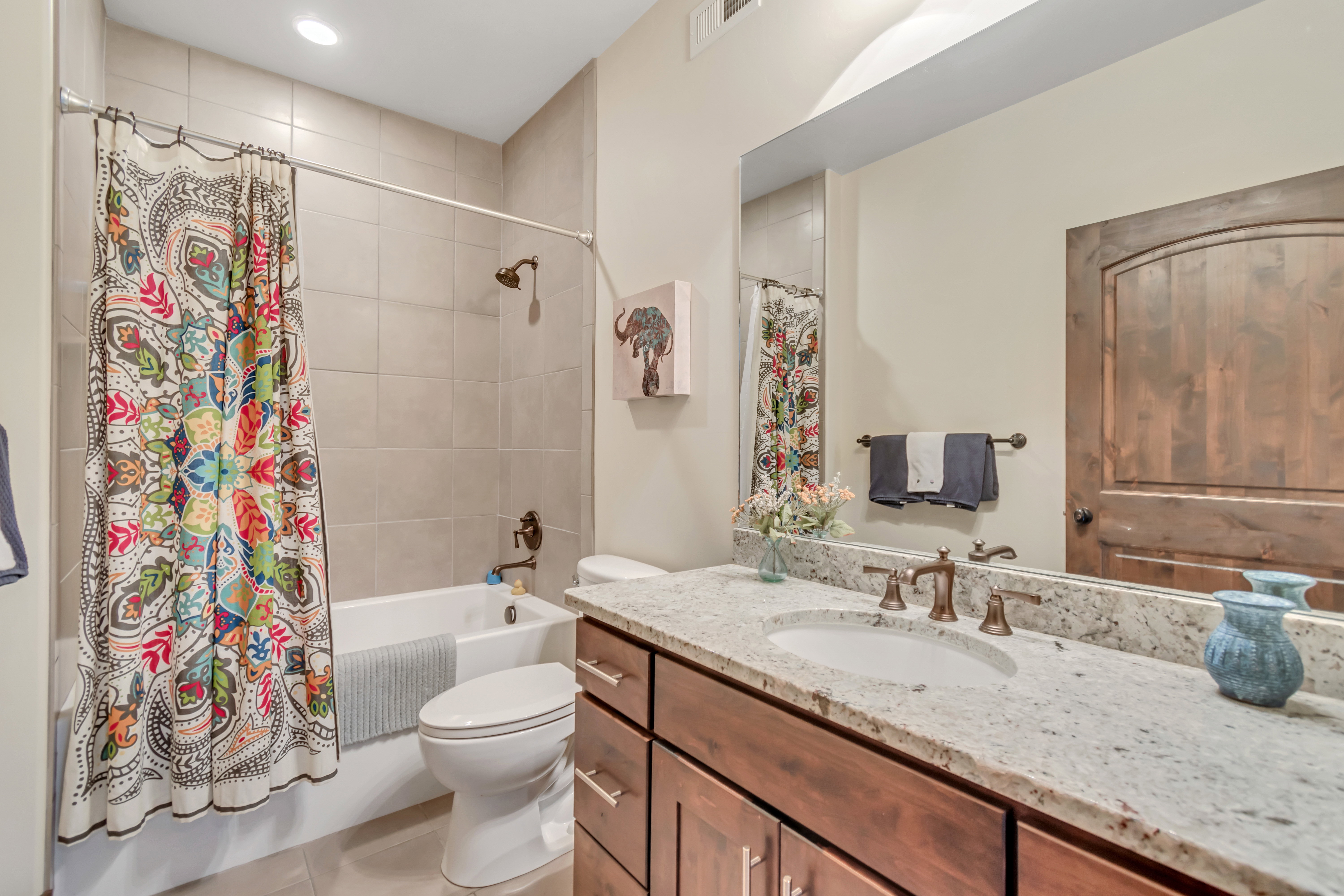 Full bath with vanity, shower / bath combination with curtain, and light tile patterned floors