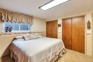Bedroom with multiple closets and light carpet