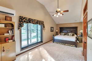 Primary bedroom featuring vaulted ceiling, light colored carpet, and a ceiling fan