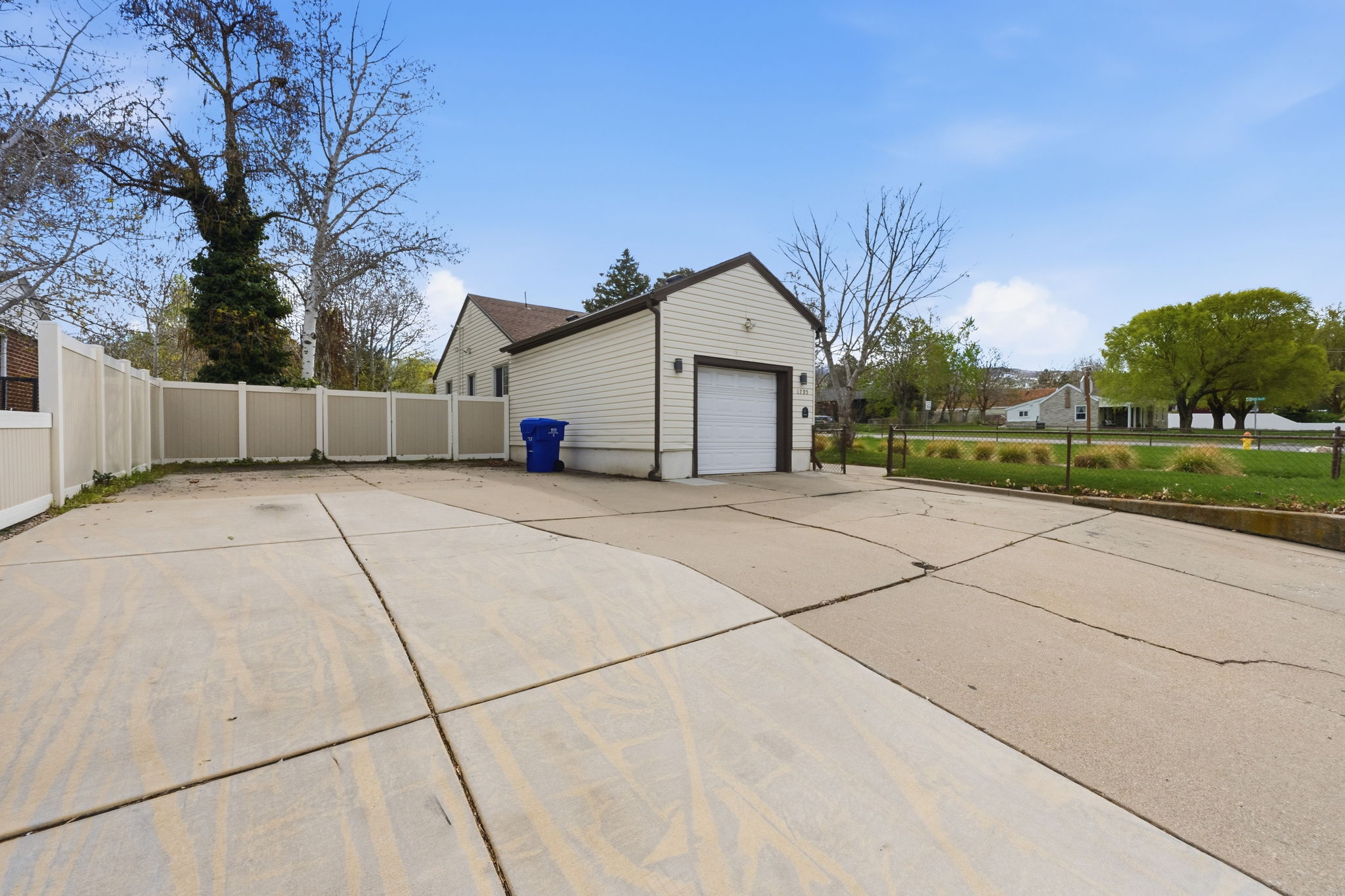 View of property exterior with concrete driveway and an outbuilding