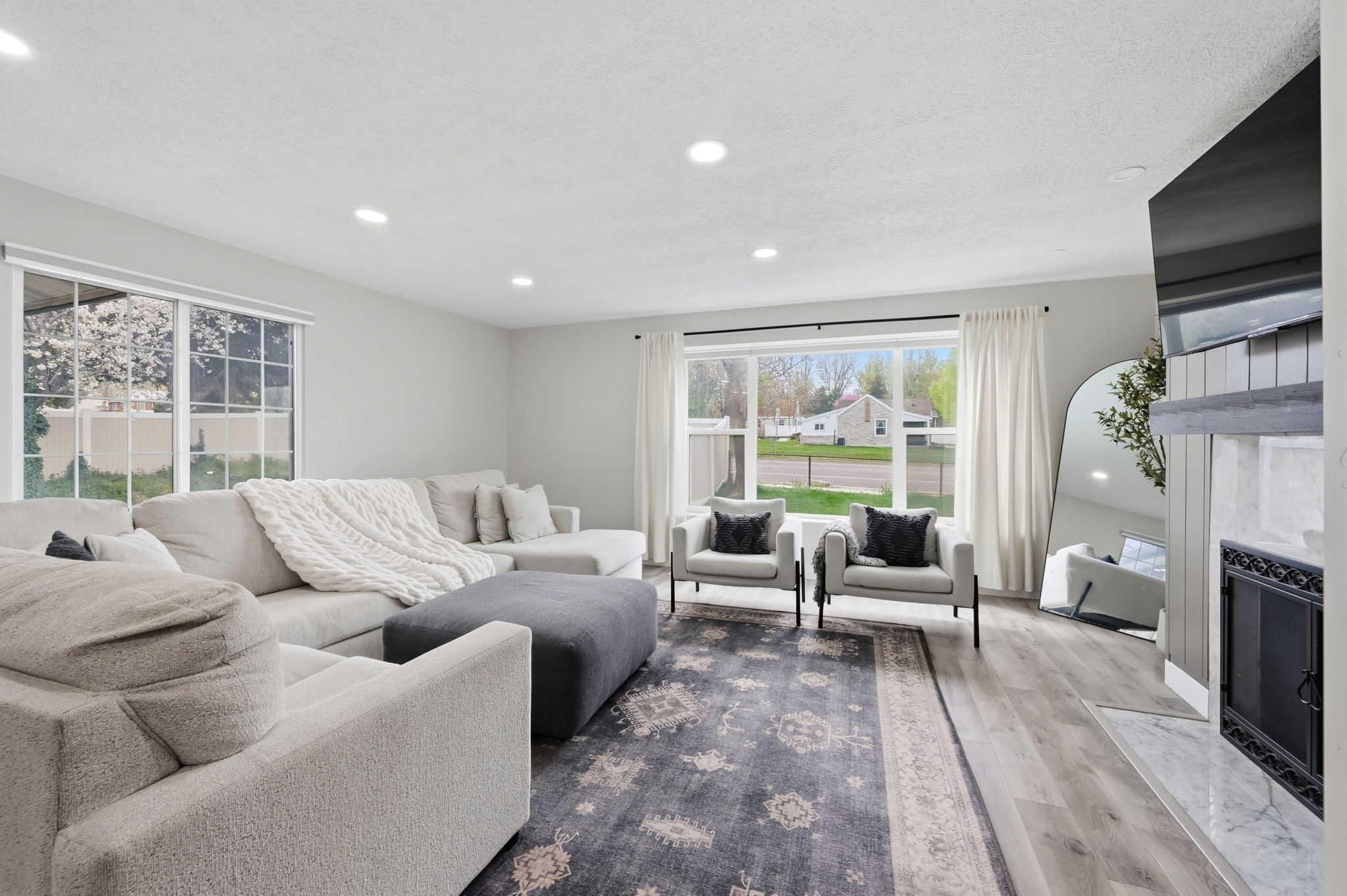 Living area with a premium fireplace, wood finished floors, and recessed lighting
