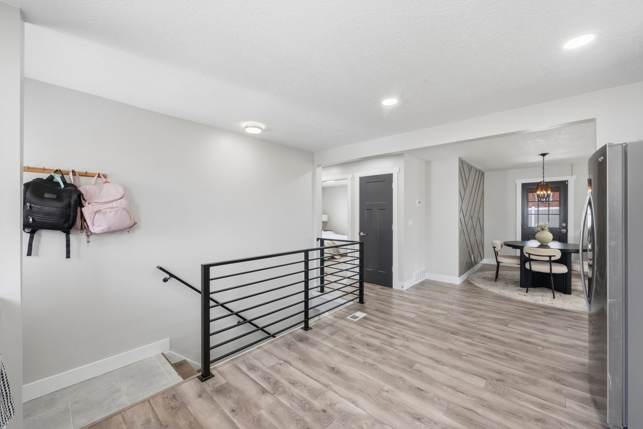 Staircase with wood finished floors and hanging lights