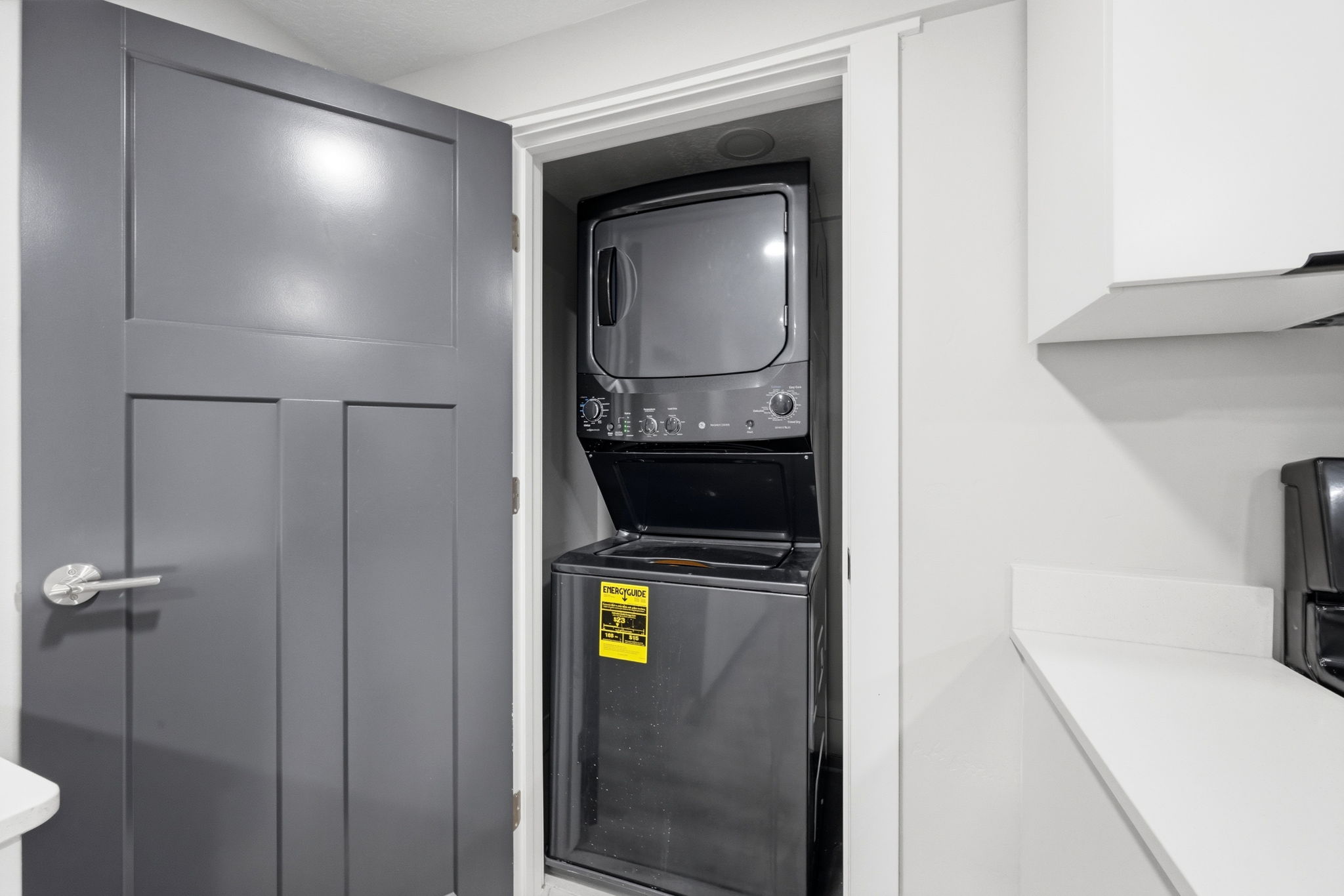Laundry area with stacked washer and dryer