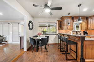 Dining area with dark wood-type flooring, BIG open window plenty of natural light, and ceiling fan