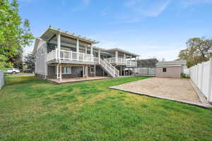Rear view of house featuring AGAIN the BIG DECK, with a shed and fenced backyard.