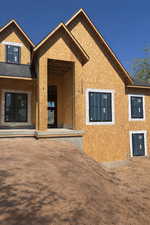 Back of property with stucco siding and covered porch