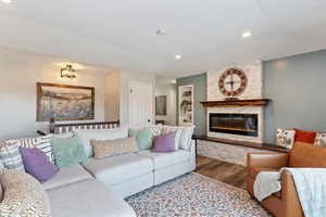 Living room featuring wood finished floors, a fireplace, and recessed lighting