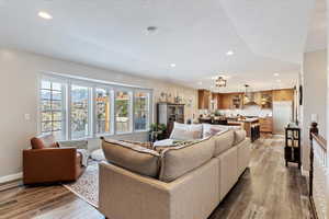 Living area with recessed lighting, light wood-style flooring, and a textured ceiling