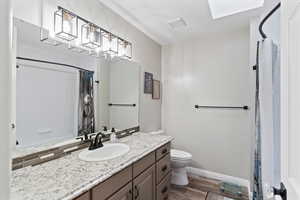 Full bath with vanity, tub, and dark wood-style flooring