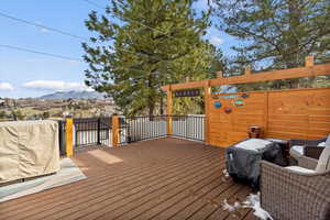 Composiite deck featuring a mountain view and area for grilling, shade system