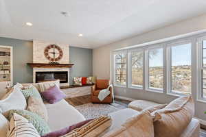 Living area with a fireplace, wood finished floors, and recessed lighting
