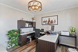 Office area featuring dark wood-type flooring, ornamental molding, and hanging lights