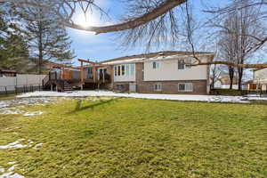 Rear view of house featuring brick and a composite deck