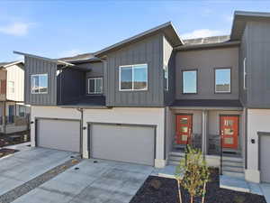 Modern home featuring an attached garage, board and batten siding, and concrete driveway