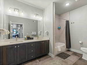 Full bathroom with double vanity and shower / bath combo