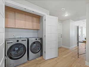 Laundry area featuring light wood-style flooring and washer and dryer