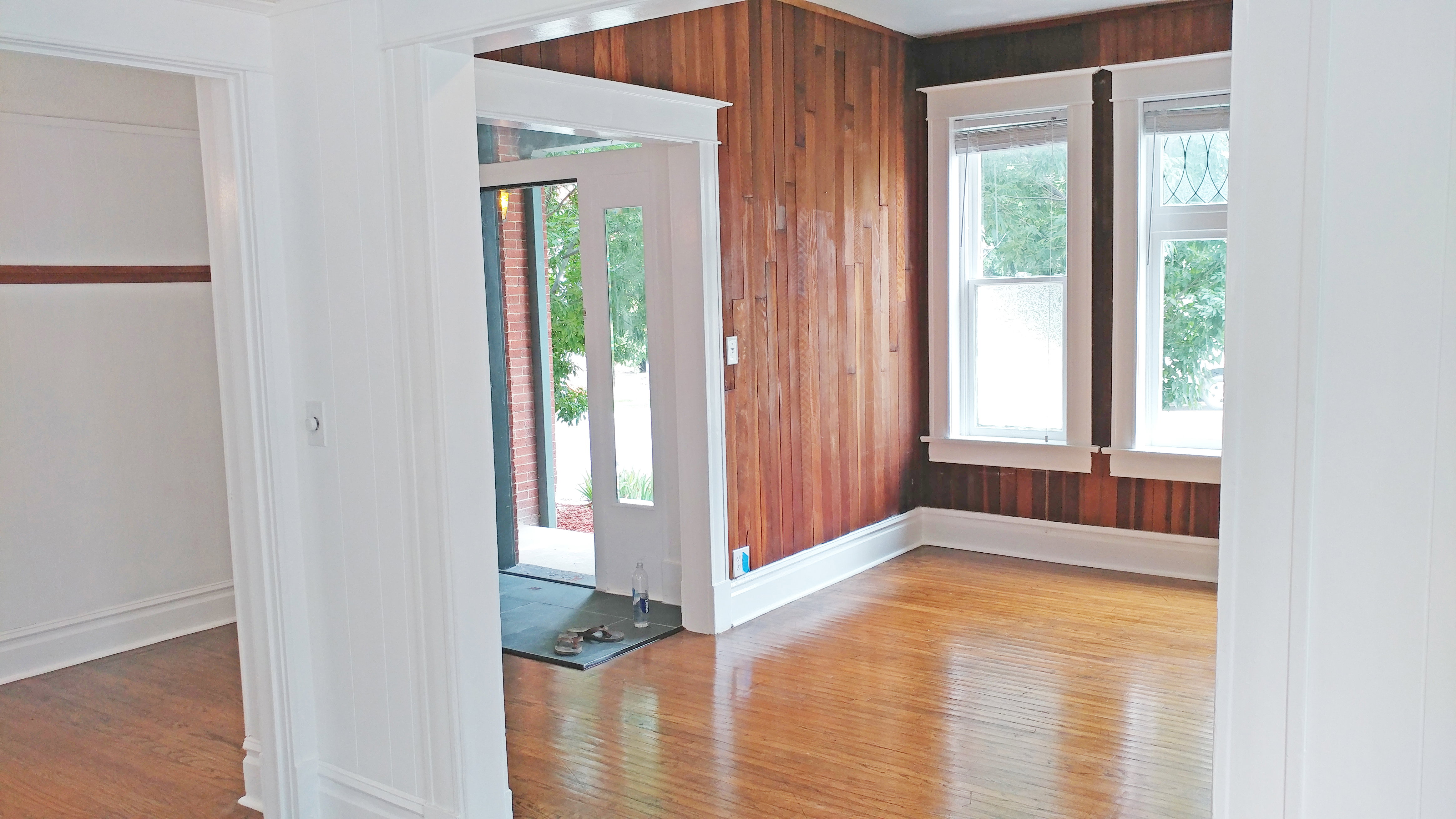 Foyer with light wood-type flooring and wood walls