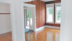 Foyer with light wood-type flooring and wood walls