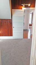 Detailed view of wood walls, carpet flooring, and a textured wall