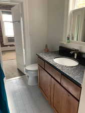 Bathroom with vanity, light colored carpet, and light tile patterned flooring
