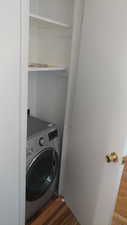 Laundry area featuring washer / dryer and dark wood-type flooring