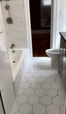 Full bath with vanity, light tile patterned flooring, and shower / tub combination