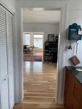 Hallway with an office area and light wood-style flooring