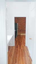 Hall with light wood-style floors and baseboards