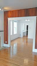 Unfurnished living room with wood walls and light wood finished floors