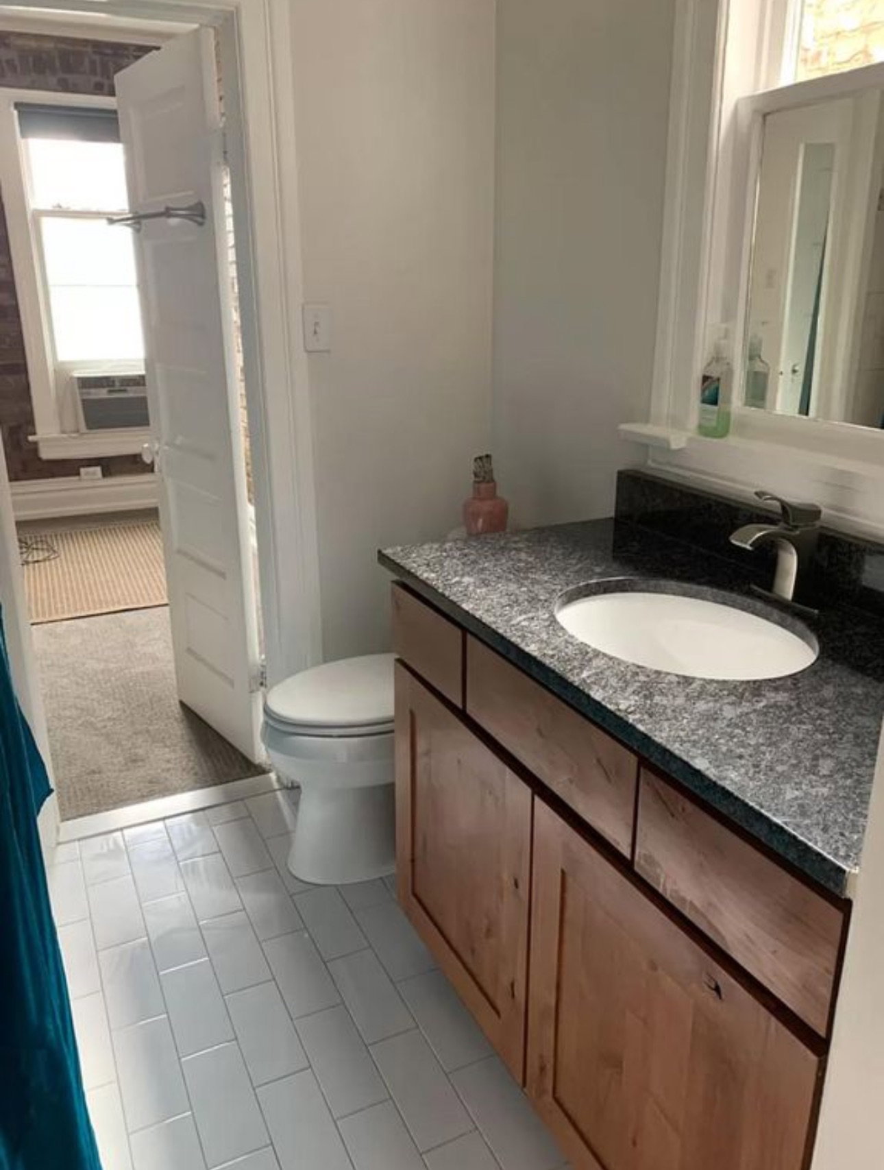 Half bathroom with vanity, light carpet, and light tile patterned floors