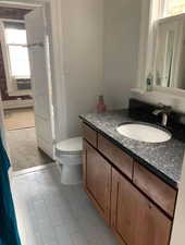 Half bathroom with vanity, light carpet, and light tile patterned floors