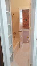 Full bathroom with light tile patterned floors, a closet, and shower / bath combination