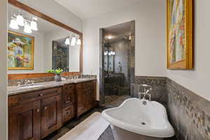 KIng Guest Bathroom featuring double vanity, a shower stall, a soaking tub, and tile walls