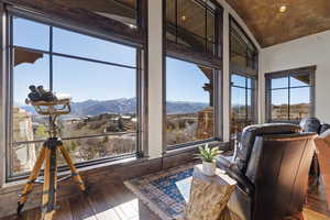 Sunroom with a mountain view, hardwood / wood-style flooring, recessed lighting, and lofted ceiling